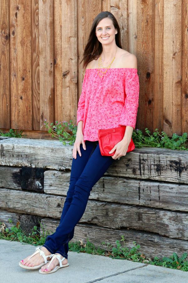 Red off-the-shoulder shirt paired with dark blue jeans.